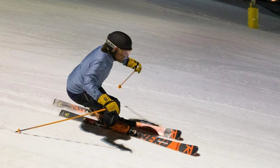 Person skiing on a snowy slope at night